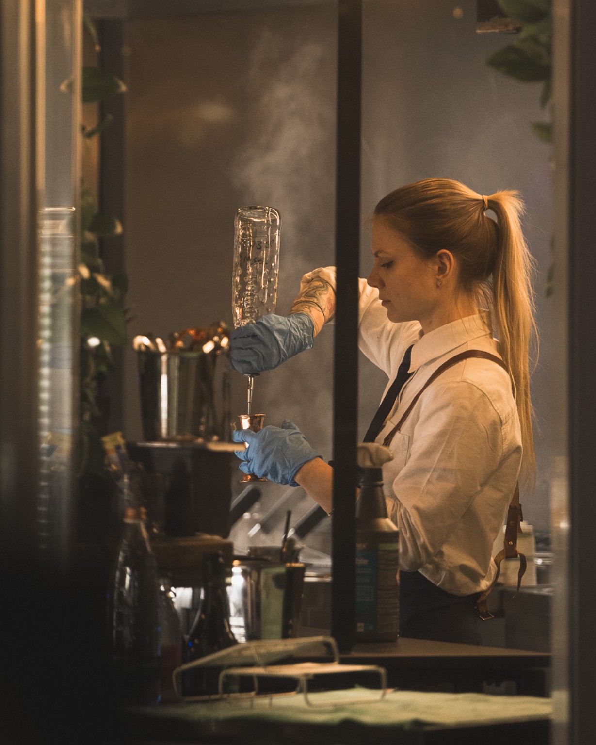 Barmanka przy pracy widziana przez szybę