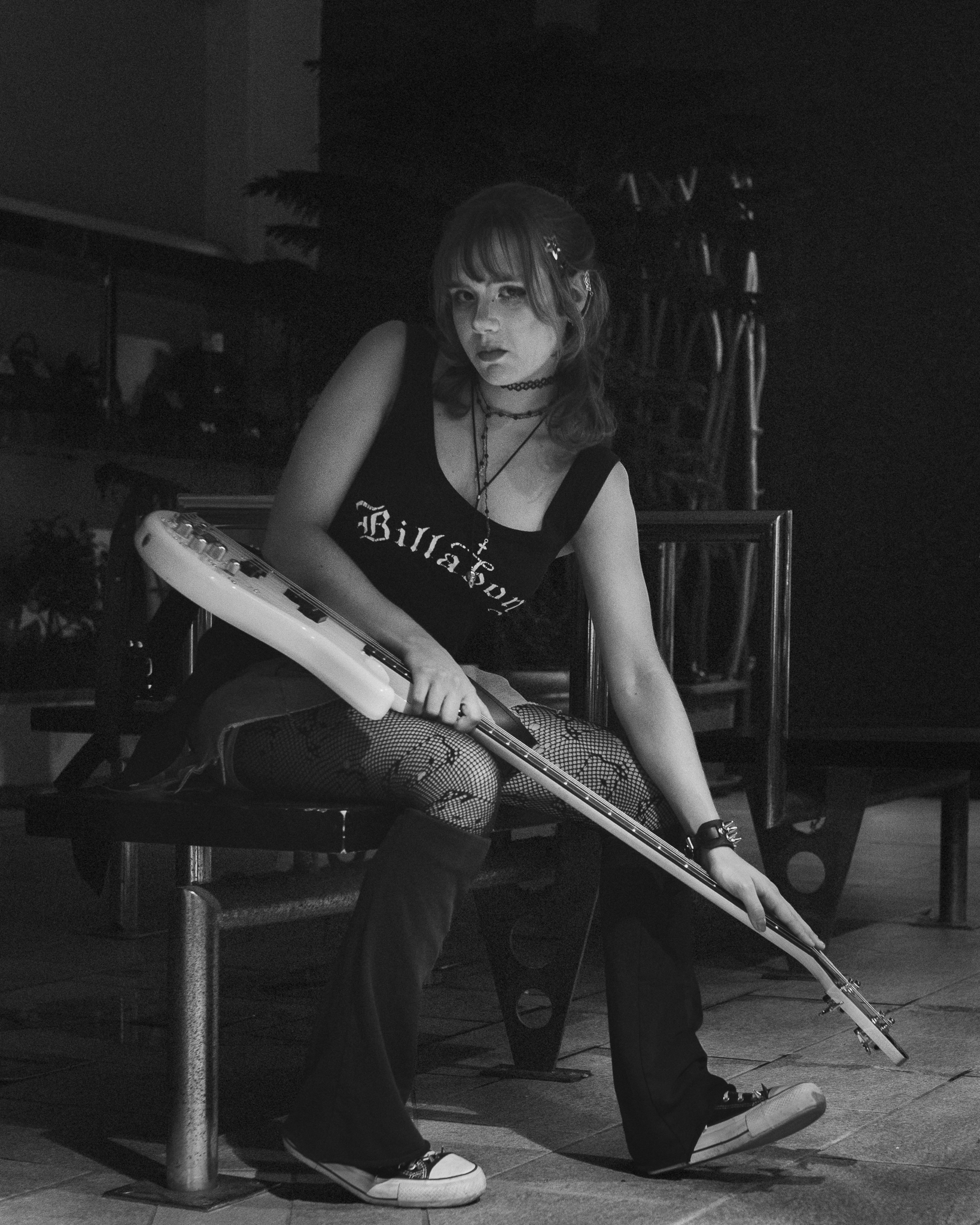 Czarno-biały portret Basi siedzącej z gitarą